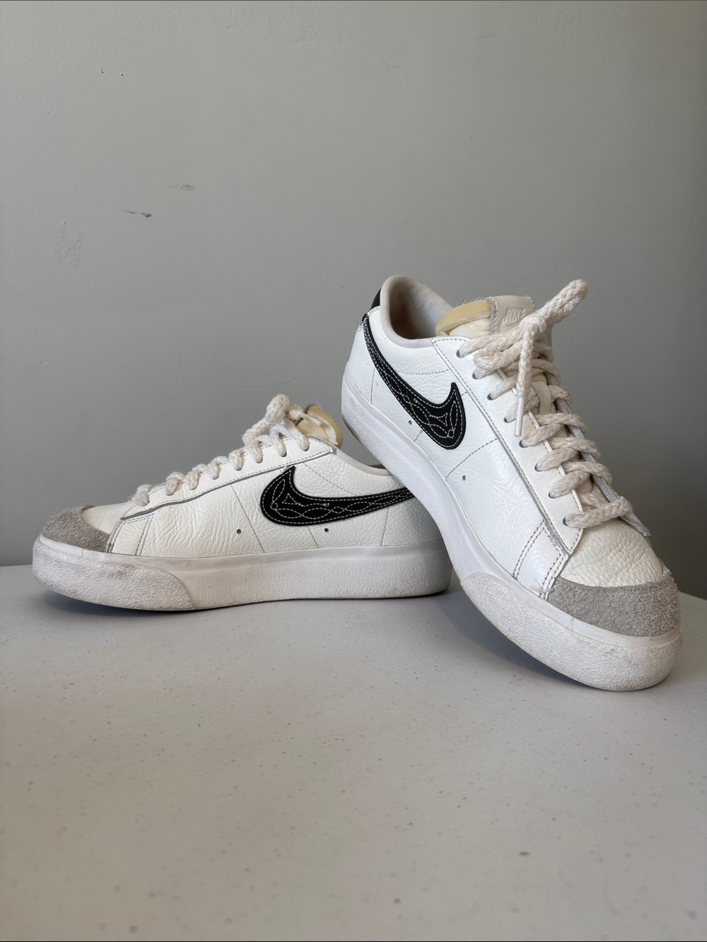 Nike White Leather Sneakers with Black Swoosh and diamond charm on back.